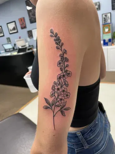 A woman has a tattoo of a flower on her arm.