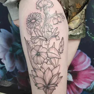 A woman has a tattoo of flowers on her leg.