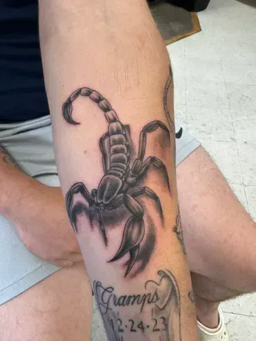 A man has a tattoo of a scorpion on his arm.