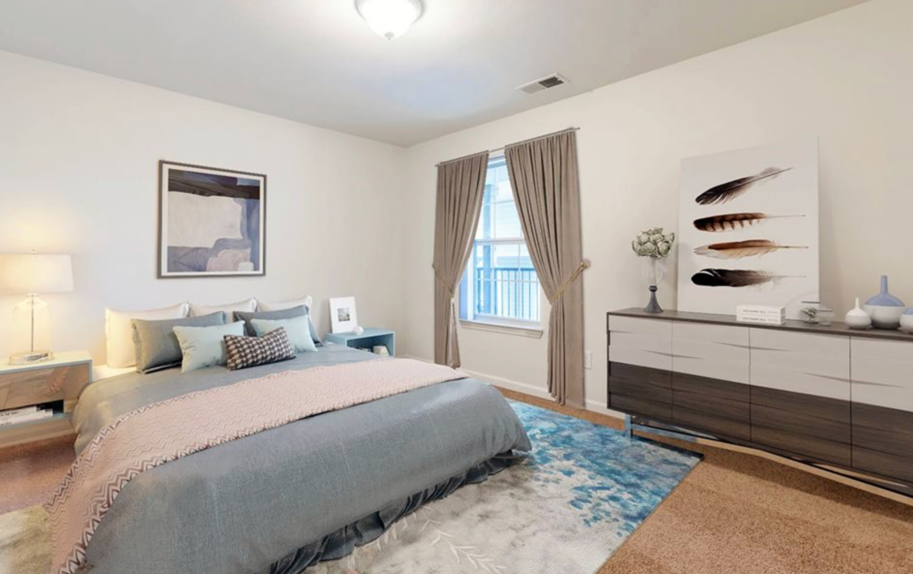 A bedroom with a bed , dresser , nightstand and window.