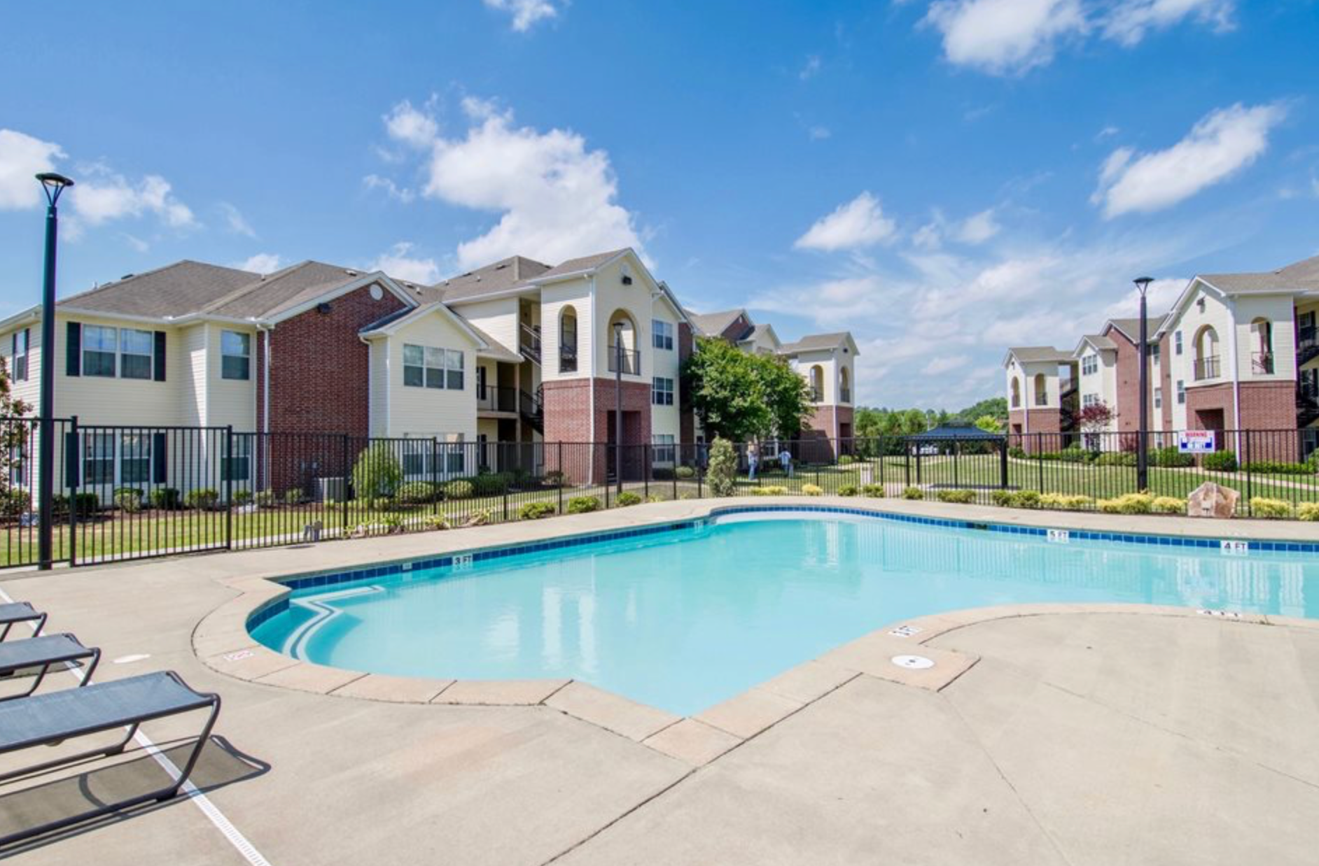 There is a large swimming pool in front of a building.