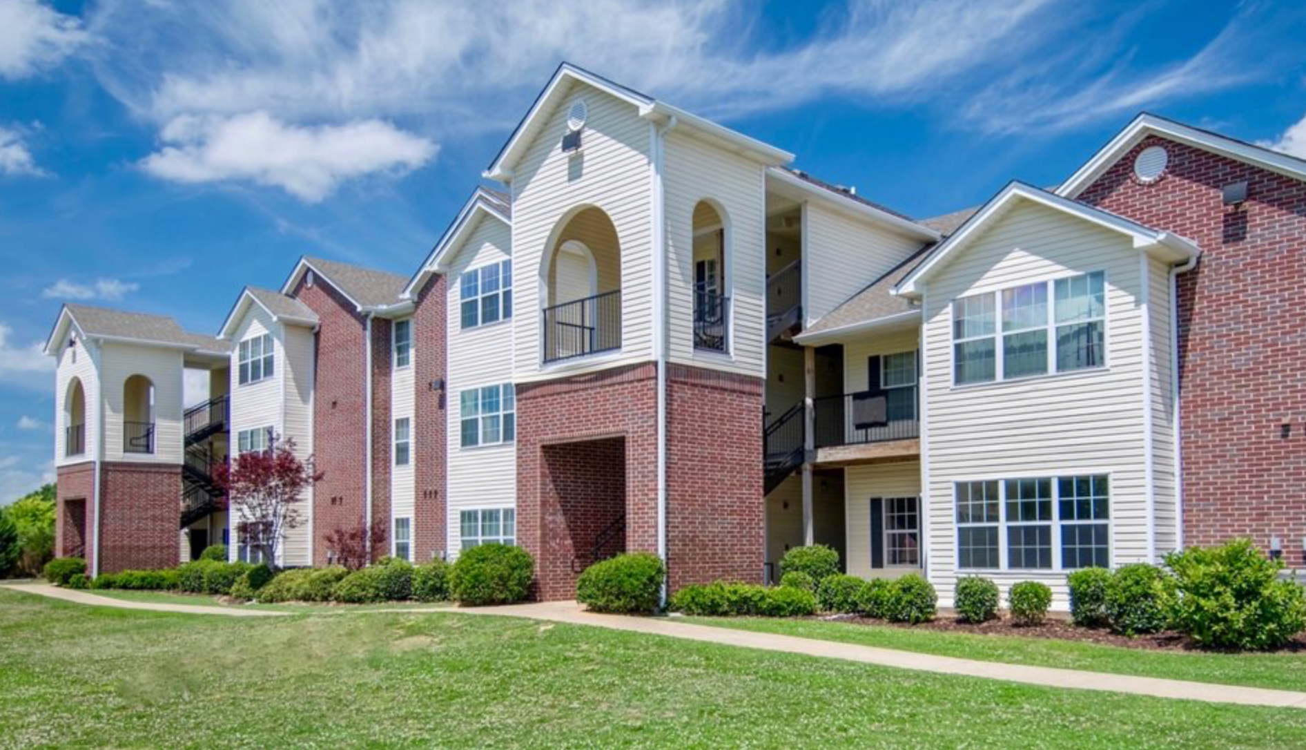 A large apartment building with a lot of windows on a sunny day.