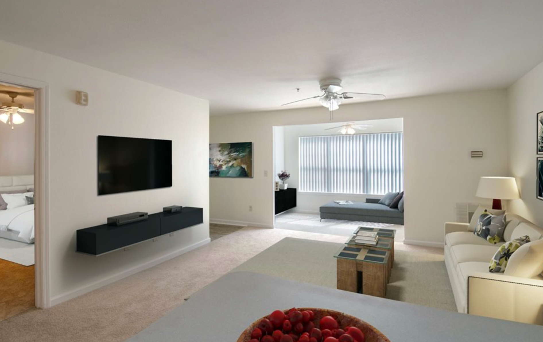 A living room with a couch and a television on the wall.