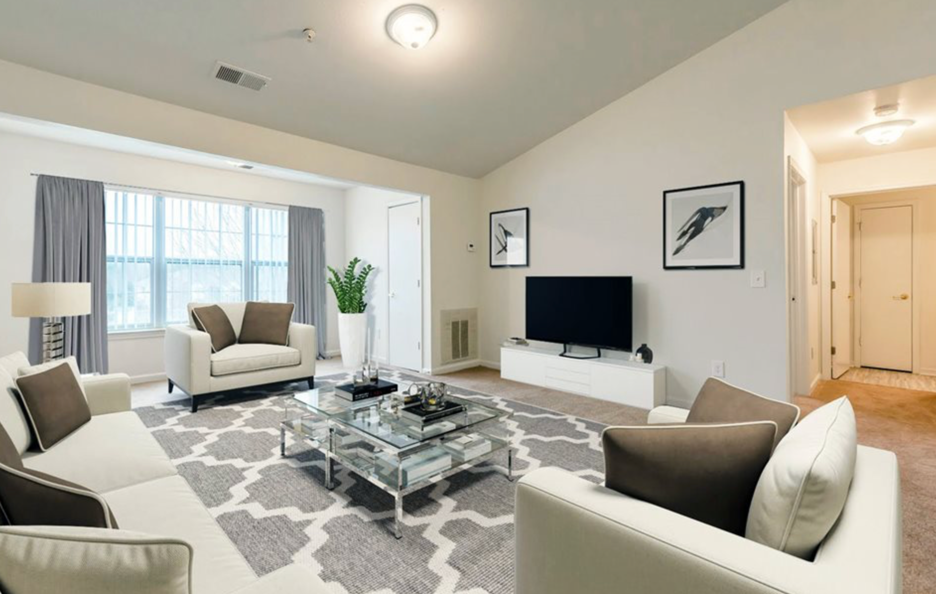 A living room with a couch , chair , coffee table and television.