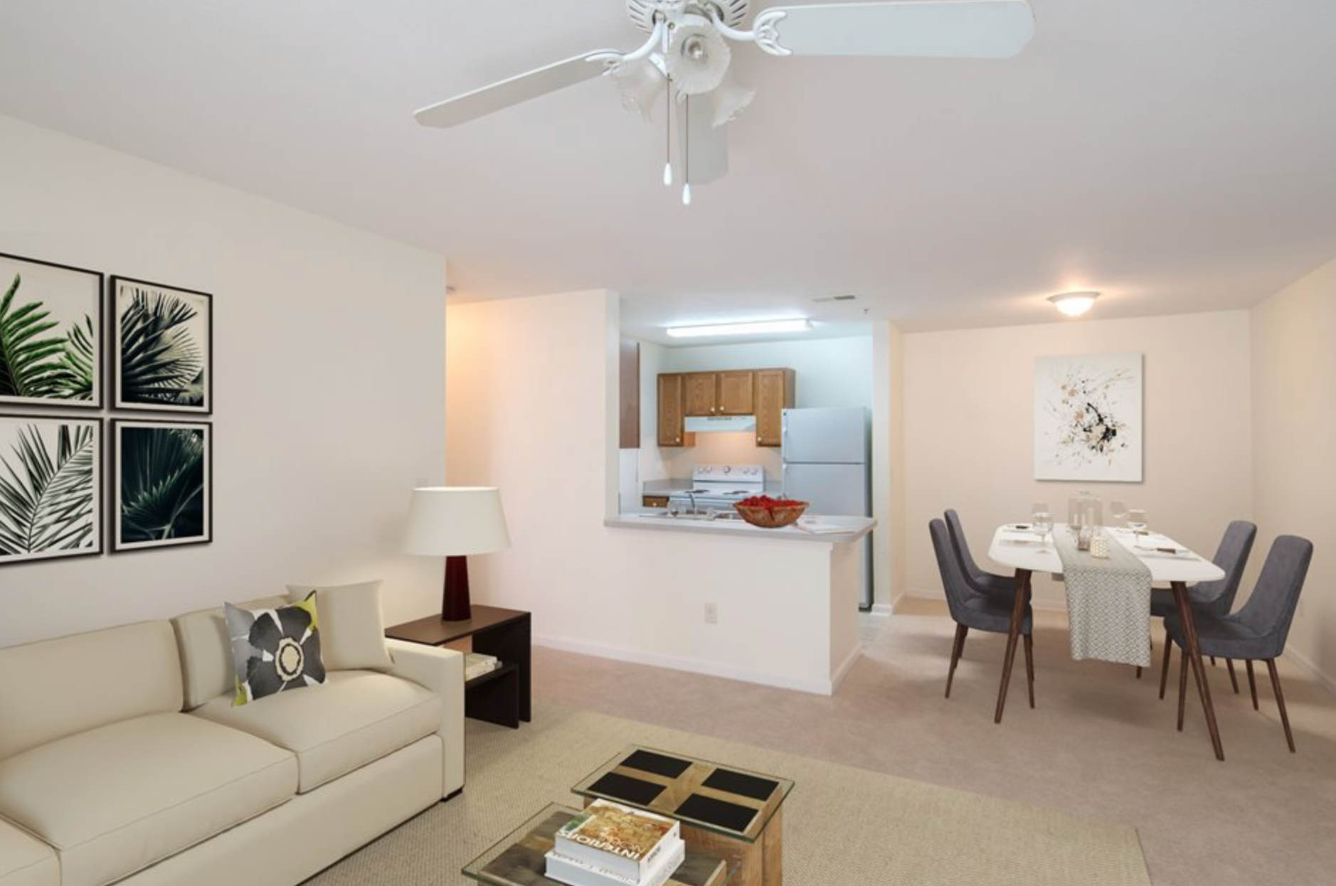 A living room with a couch , table , chairs and a ceiling fan.