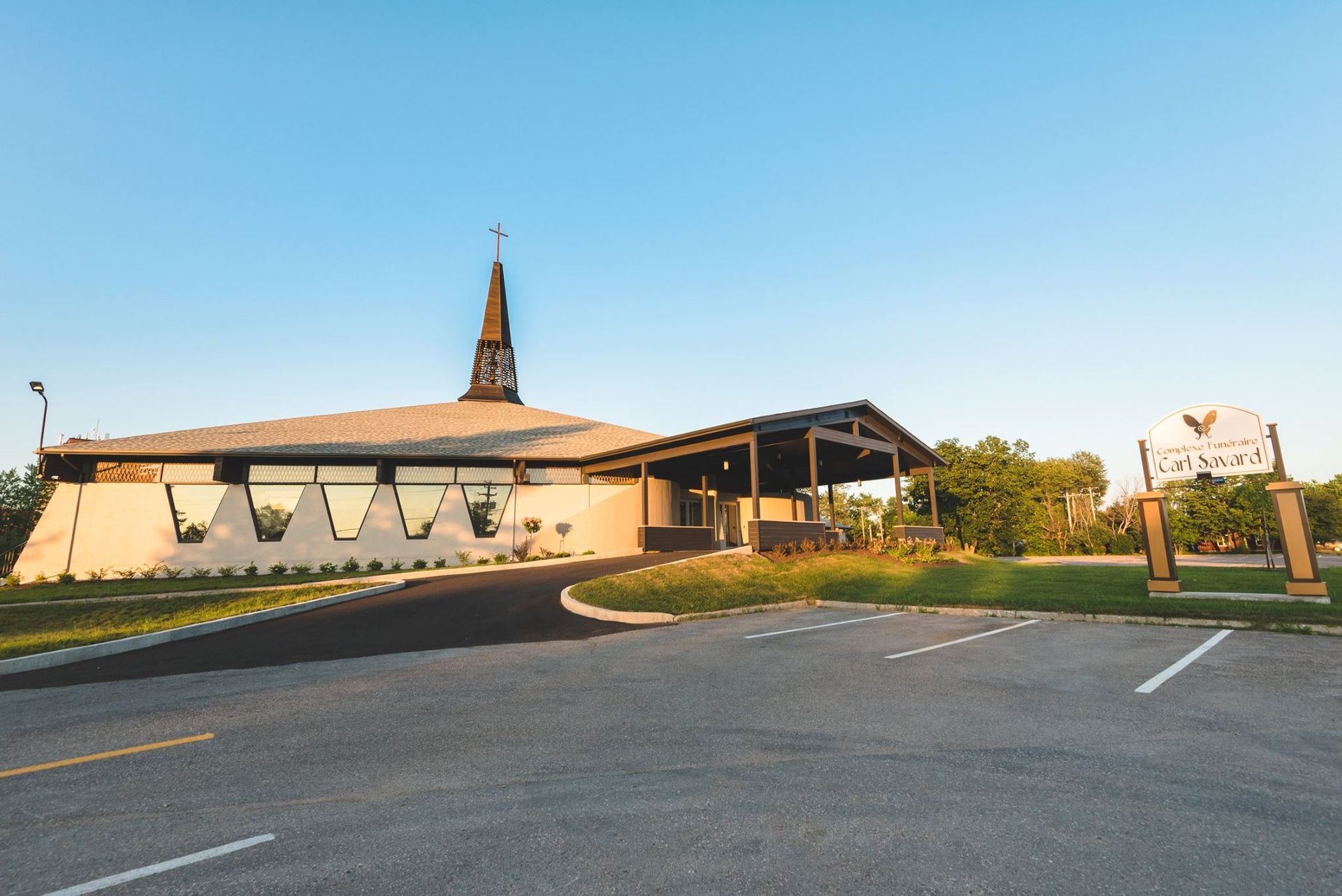 Une église avec un clocher et un panneau devant