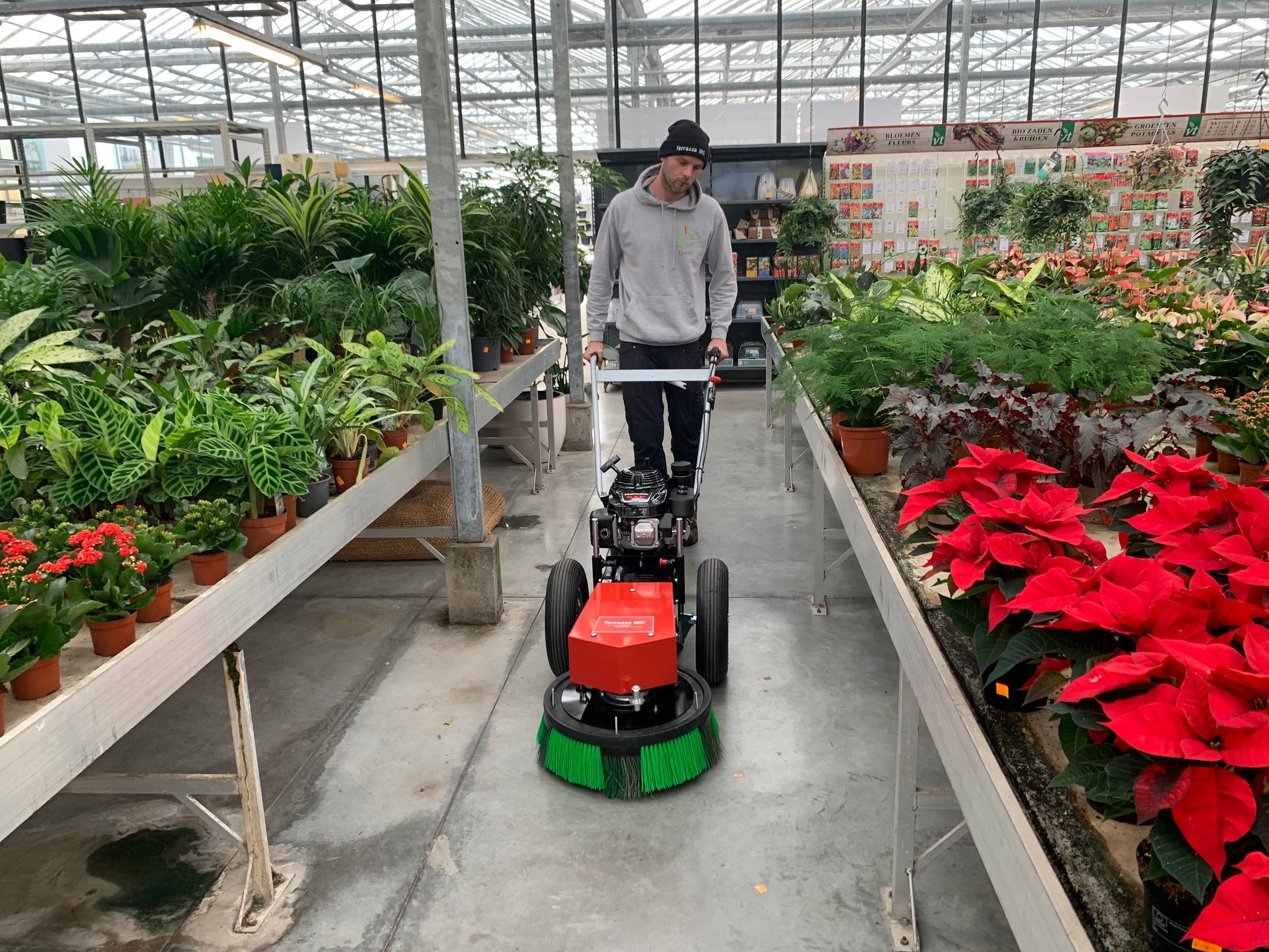Man working with the cleaning machine in a garden centre.