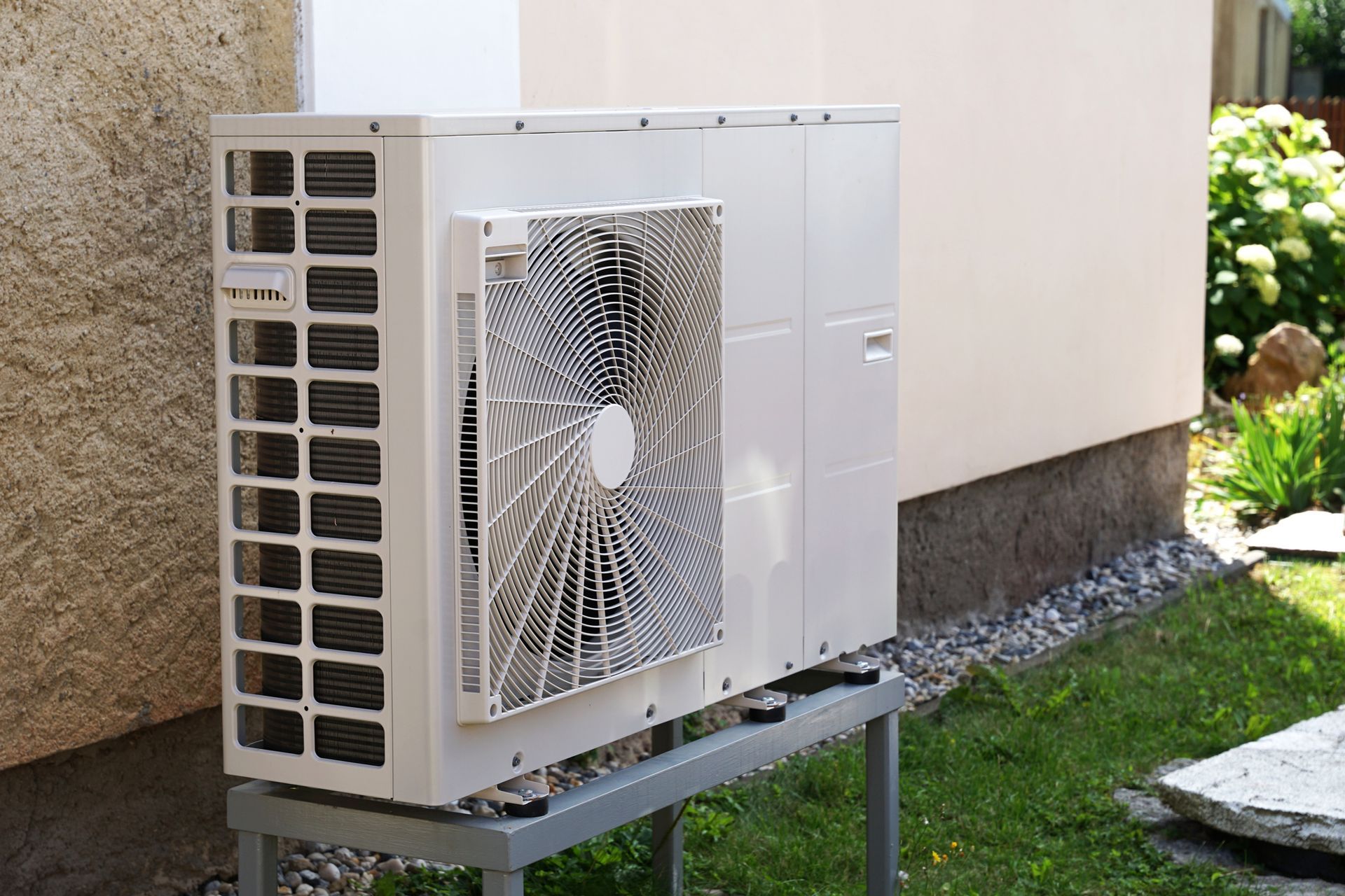 A white air conditioner is sitting outside of a building. A white air conditioner is sitting outside of a building.