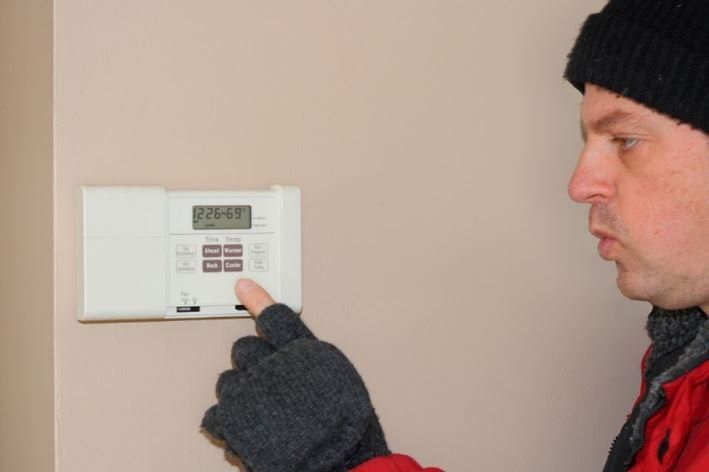 Man Adjusting The Thermostat — Ogden, UT — Comfort Solutions