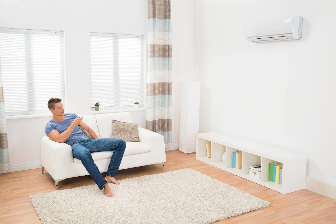 Man Using Air Conditioner — Ogden, UT — Comfort Solutions Man Using Air Conditioner — Ogden, UT — Comfort Solutions