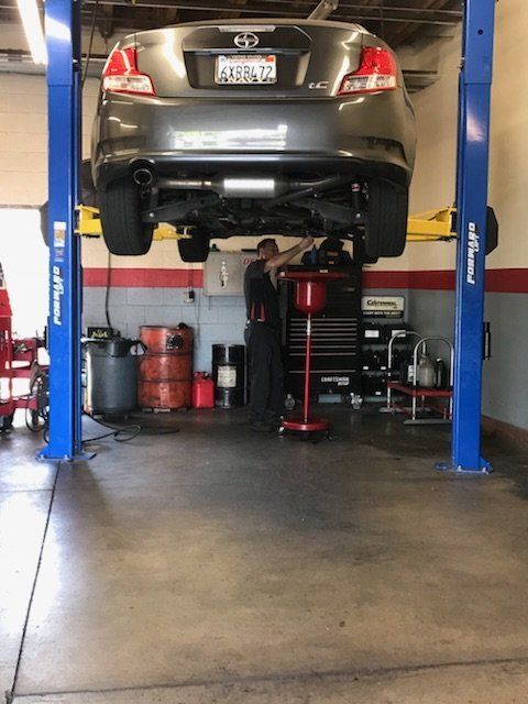 Car Repair — Mechanic Fixing the Under Part of a Car in Cypress, CA