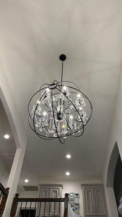 A large chandelier is hanging from the ceiling in a living room.