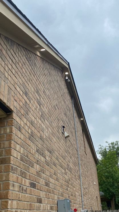 A brick building with a roof and a gutter on it.