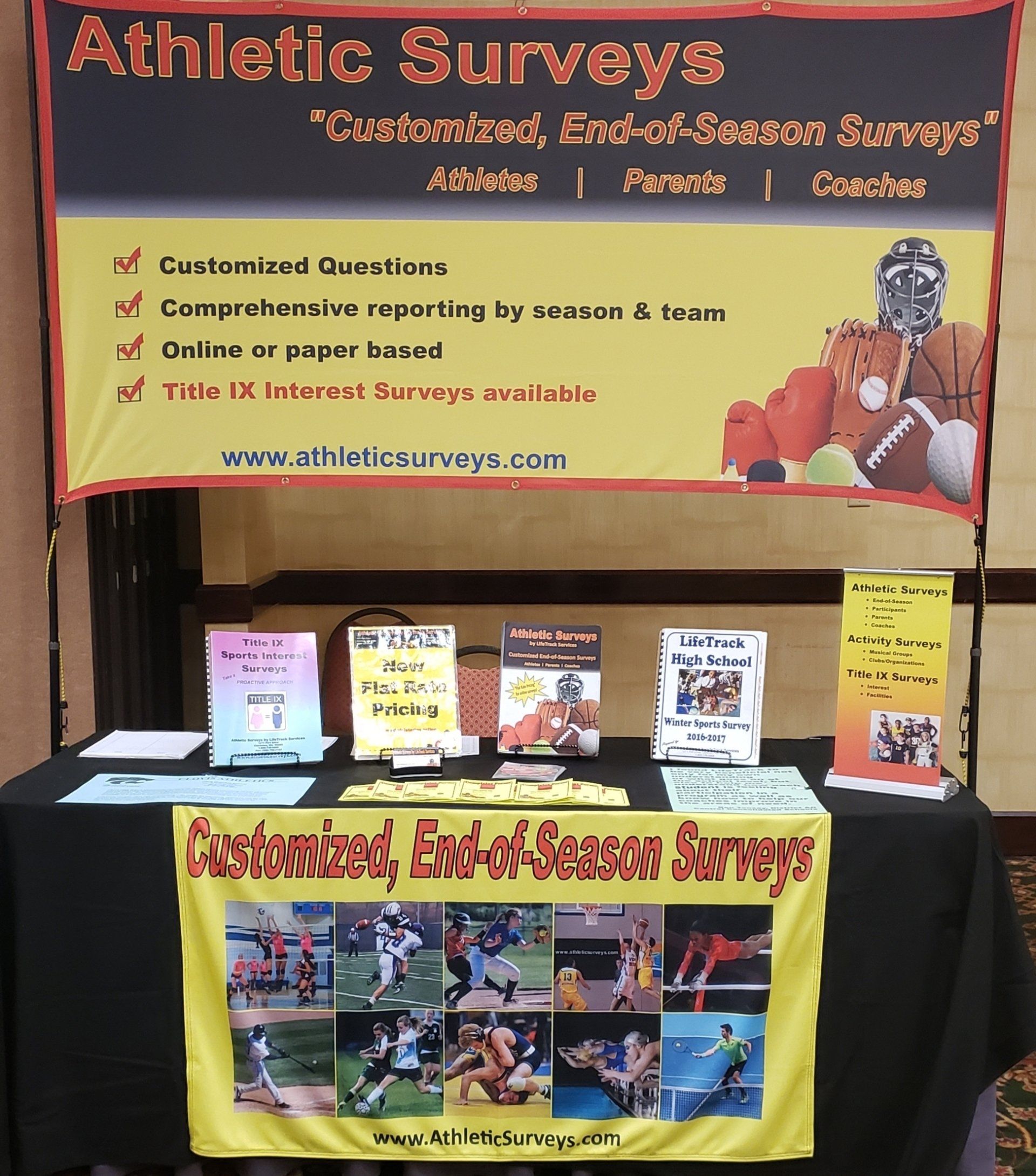 Booth promoting athletic surveys: banner with text and sports photos, brochures on a table.