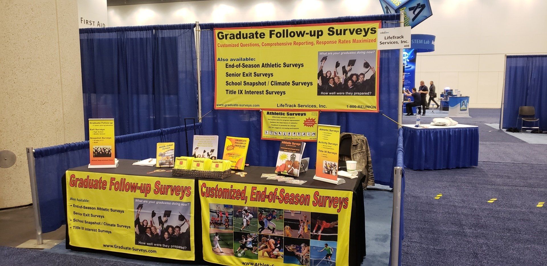 An exhibit booth at a conference with signs reading
