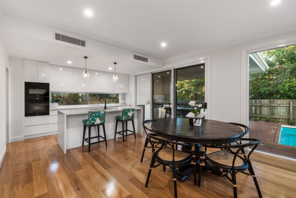 A Living Room With Two Red Couches and a Fireplace — Peter Betros Homes in Highfields, QLD