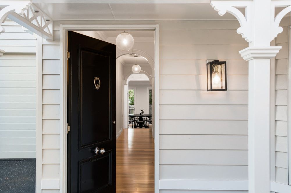 A black door is open to a white house — Peter Betros Homes in Highfields, QLD