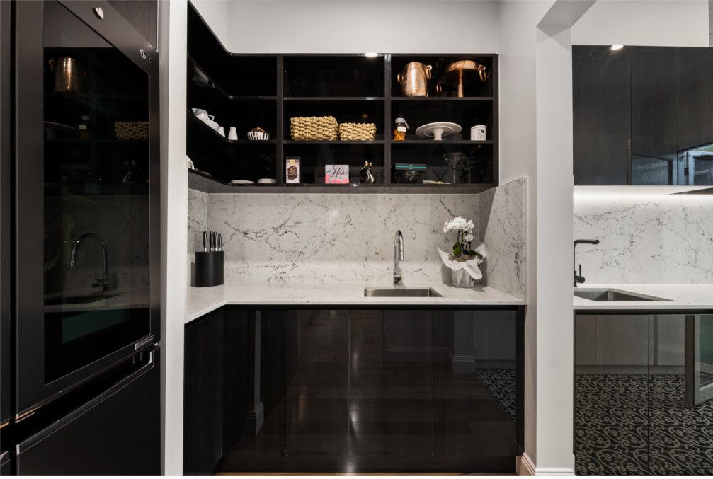 A kitchen with black cabinets and white counter tops — Peter Betros Homes in Highfields, QLD