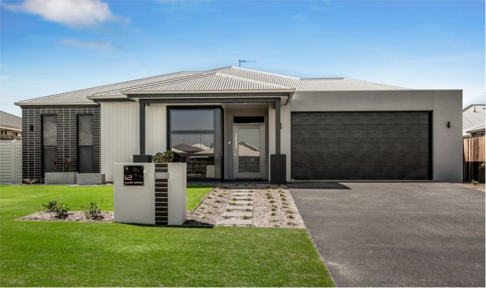 A Modern House With a Black Garage Door — Peter Betros Homes in Highfields, QLD