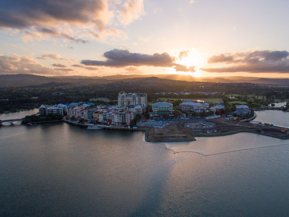 An Aerial View of a City Surrounded by Water at Sunset — Dean Gray Tiling In Gold Coast, QLD