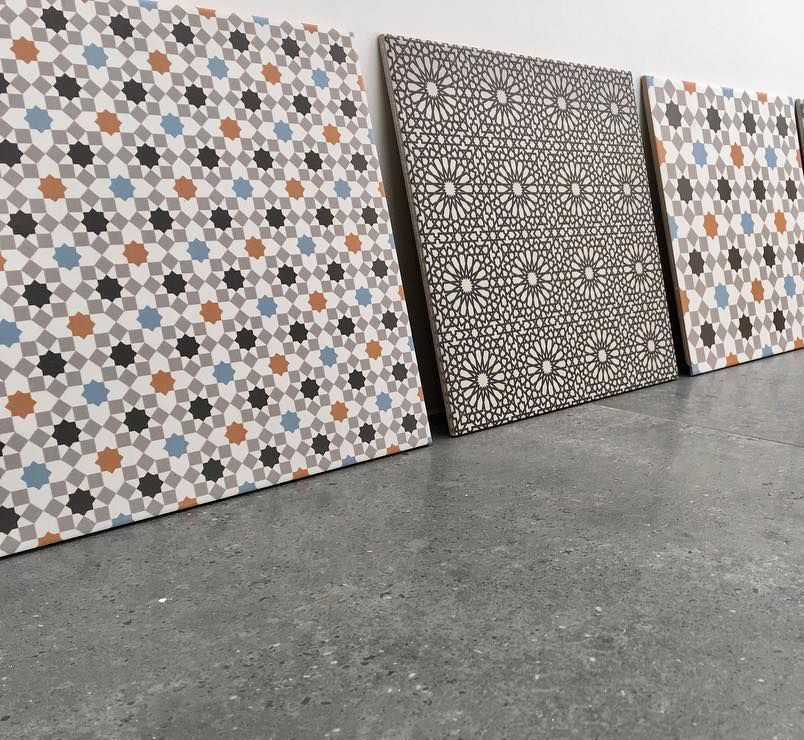Three Tiles With Different Patterns Are Lined Up on a Concrete Floor — Dean Gray Tiling in Hastings Point, NSW