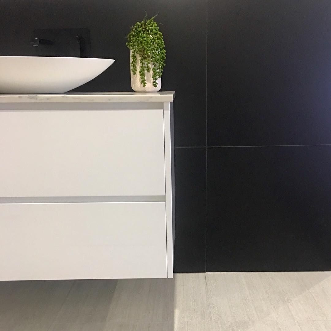 A Bathroom Vanity With a Sink and a Plant on Top of It — Dean Gray Tiling in Robina, QLD