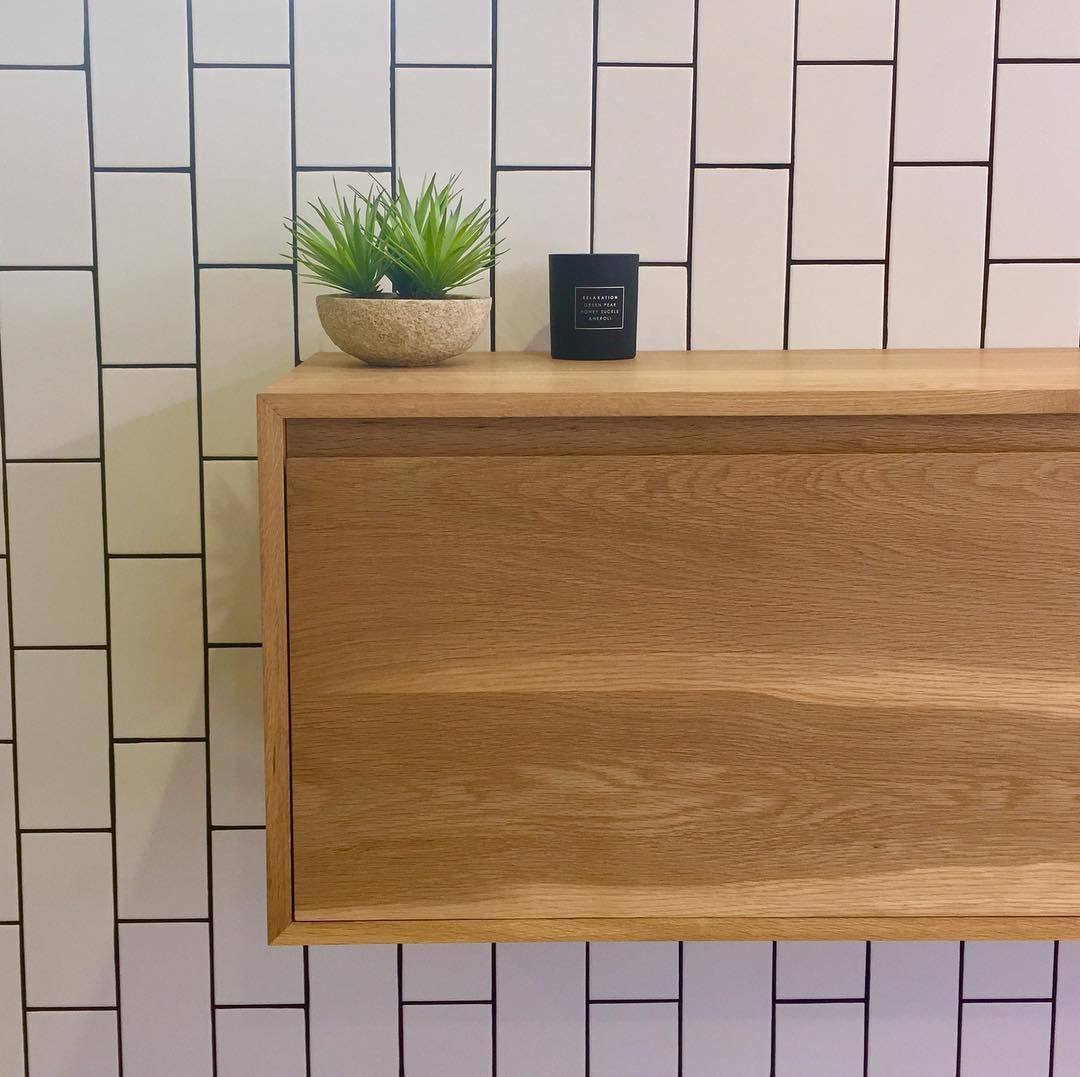 A Wooden Shelf With a Plant and a Candle on It — Dean Gray Tiling in Pottsville, NSW