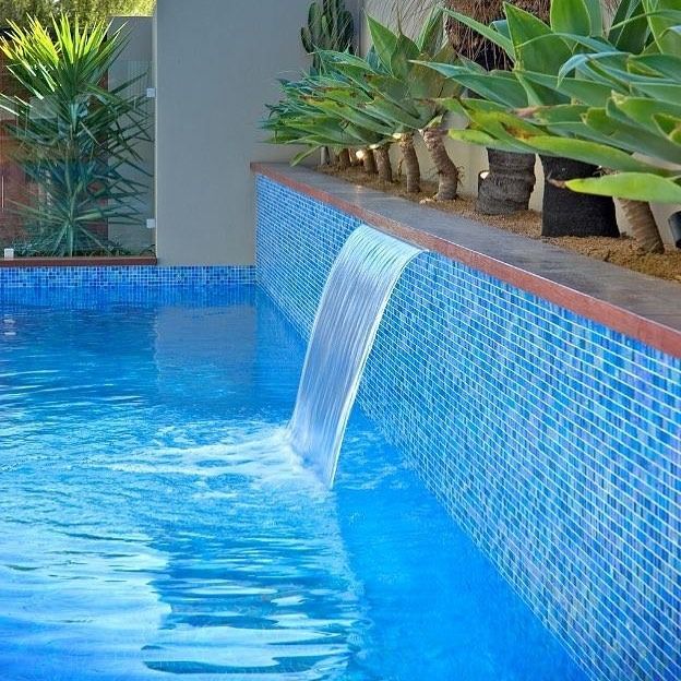 A Swimming Pool With a Waterfall in the Middle of It — Dean Gray Tiling in Ballina, NSW