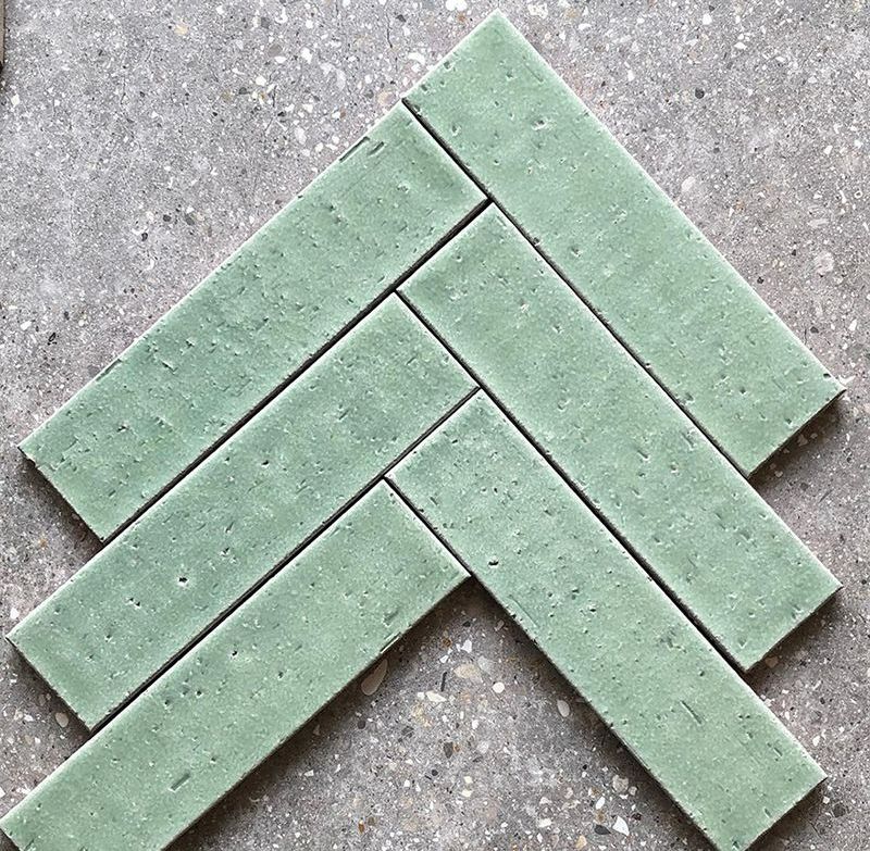 A Close Up of a Herringbone Pattern of Green Tiles on a Concrete Surface — Dean Gray Tiling in Hastings Point, NSW