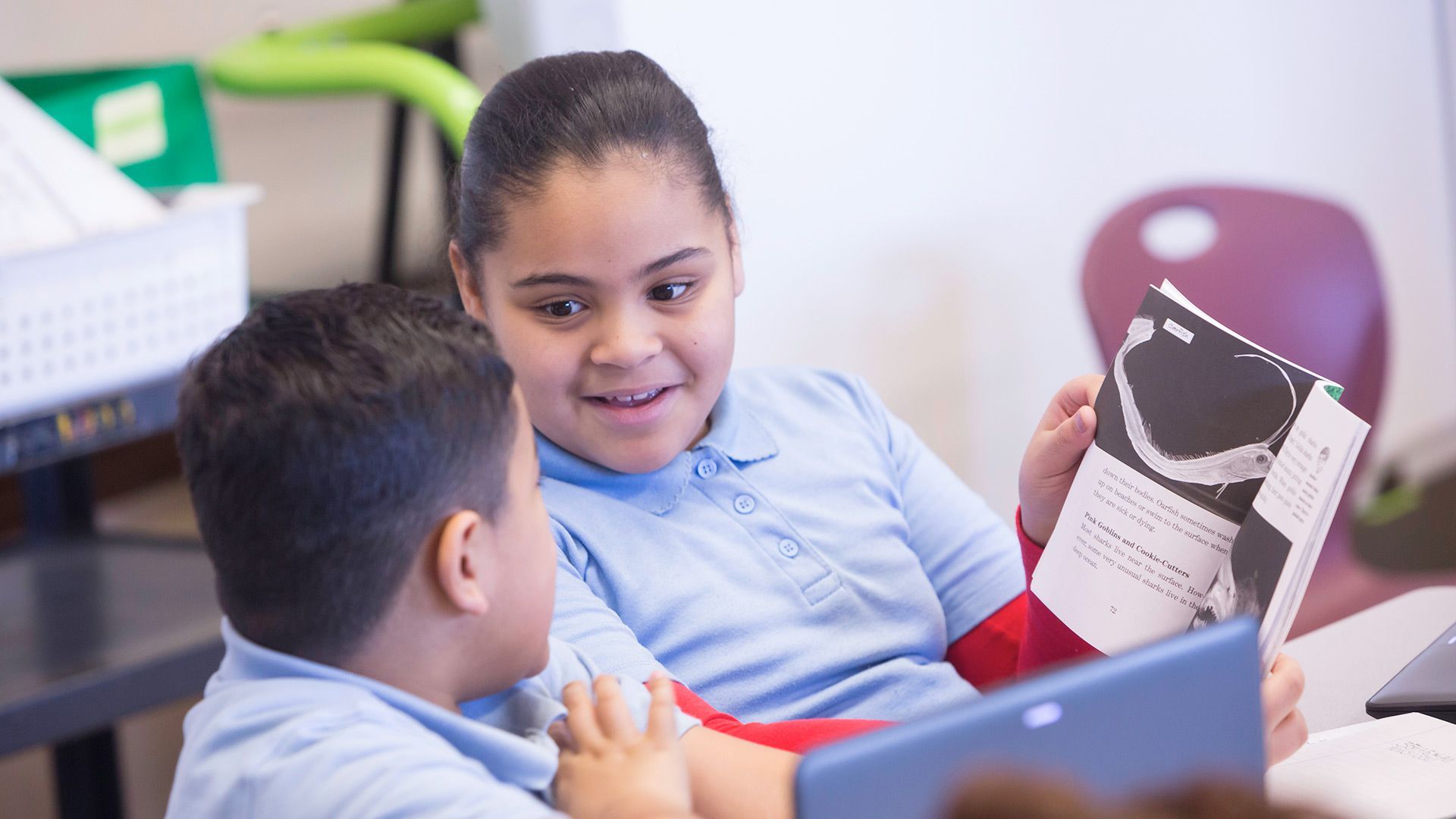 A boy and a girl are reading a book together