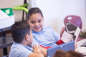 A boy and a girl are reading a book together