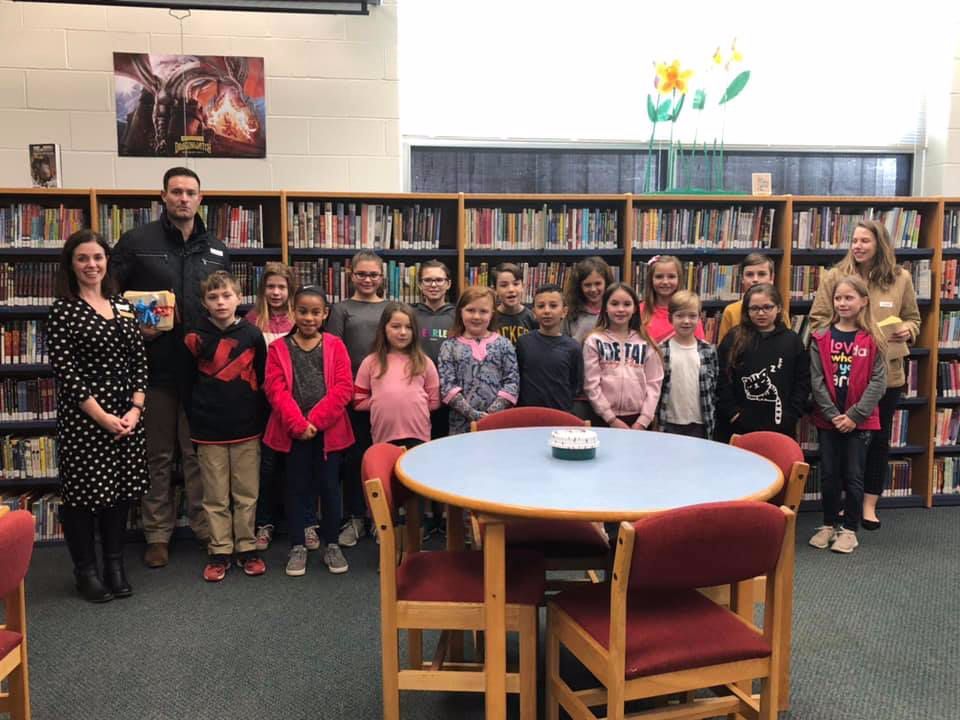 A group of children are posing for a picture in a library
