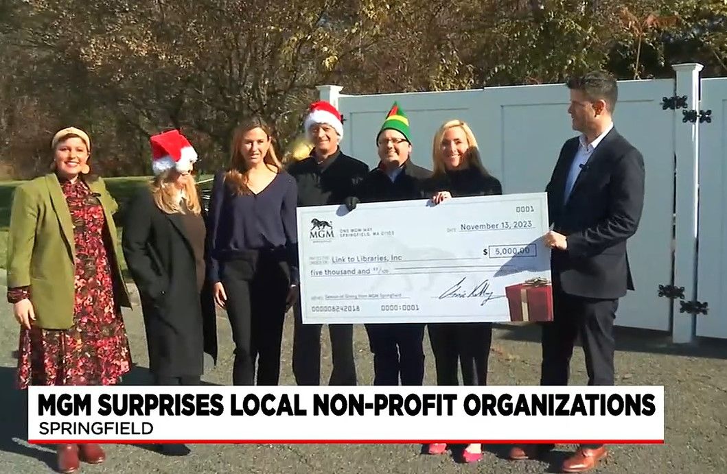 A group of people standing next to each other holding a large check.