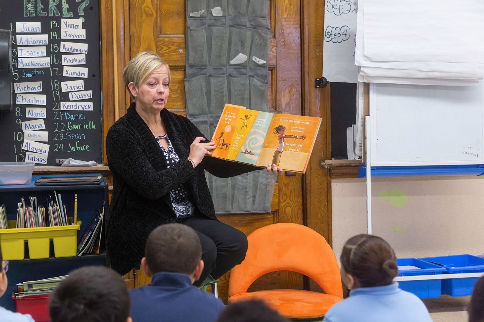 A woman is reading a book to a group of children