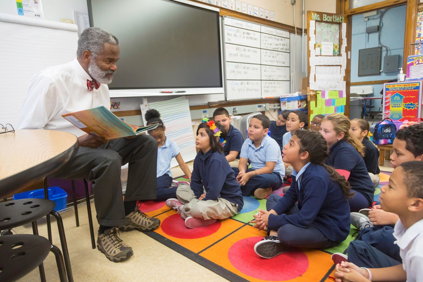 A man is reading a book to a group of children