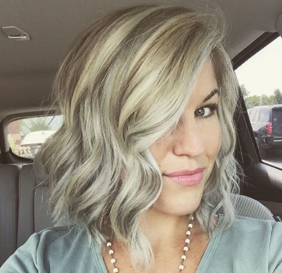 A woman with gray hair is sitting in a car.