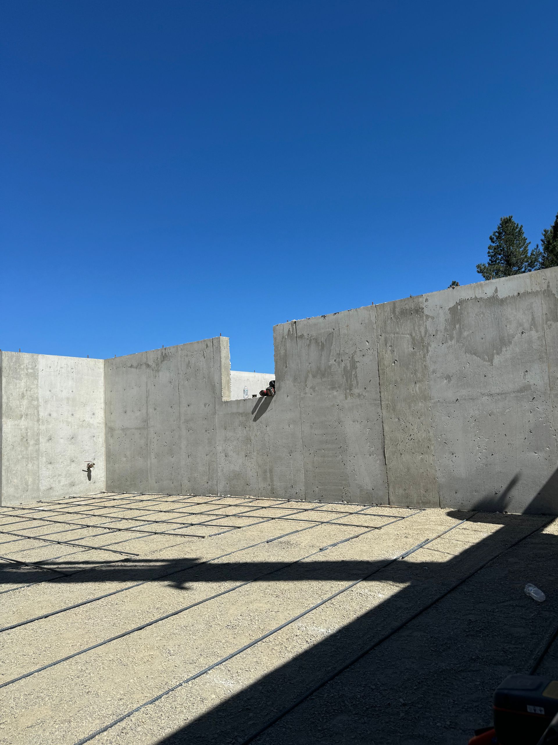 A concrete wall with a blue sky in the background. Project done by Raise the Bar Construction