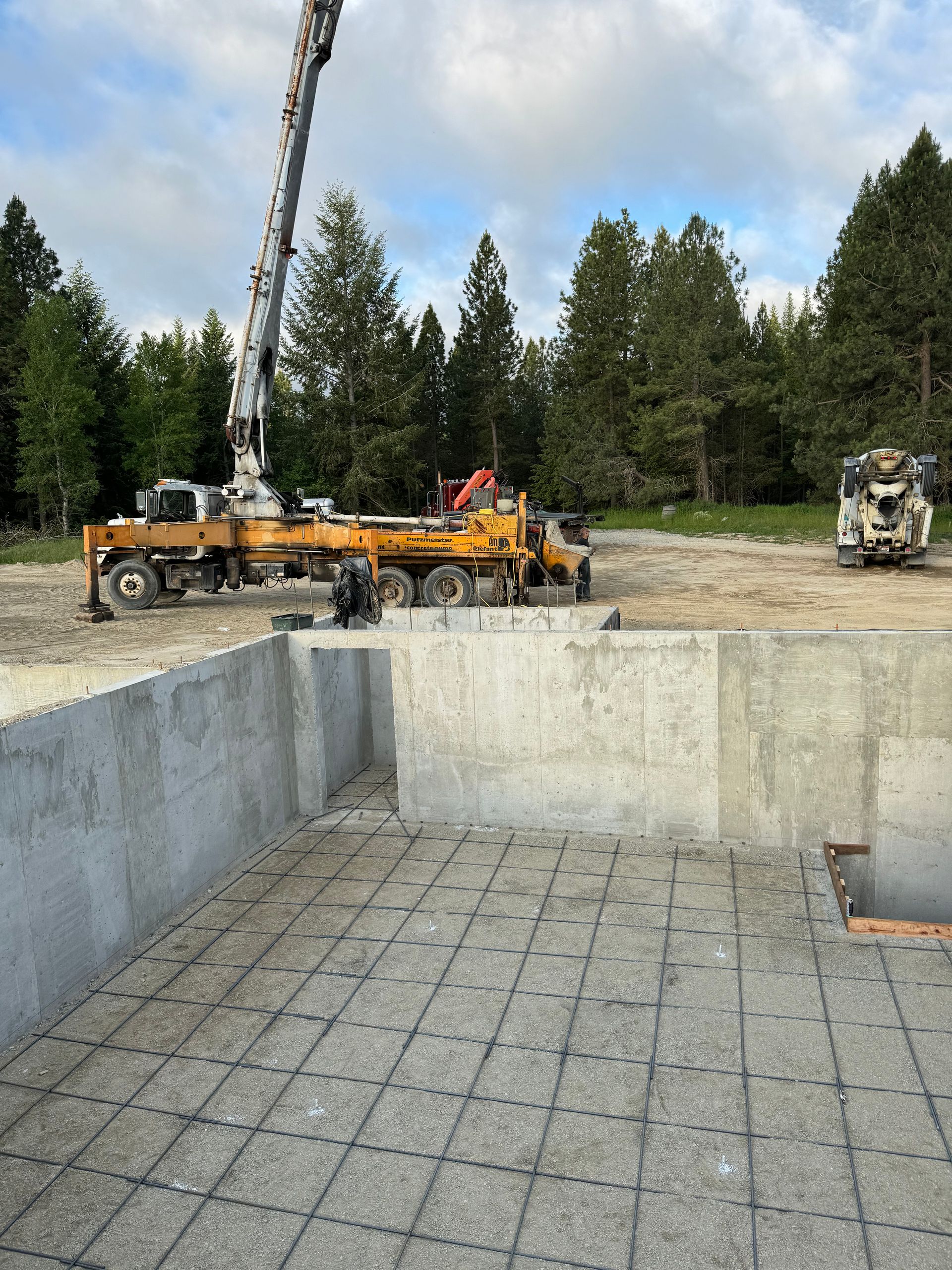 A crane is being used to pump concrete into a pool. Project done by Raise the Bar Construction