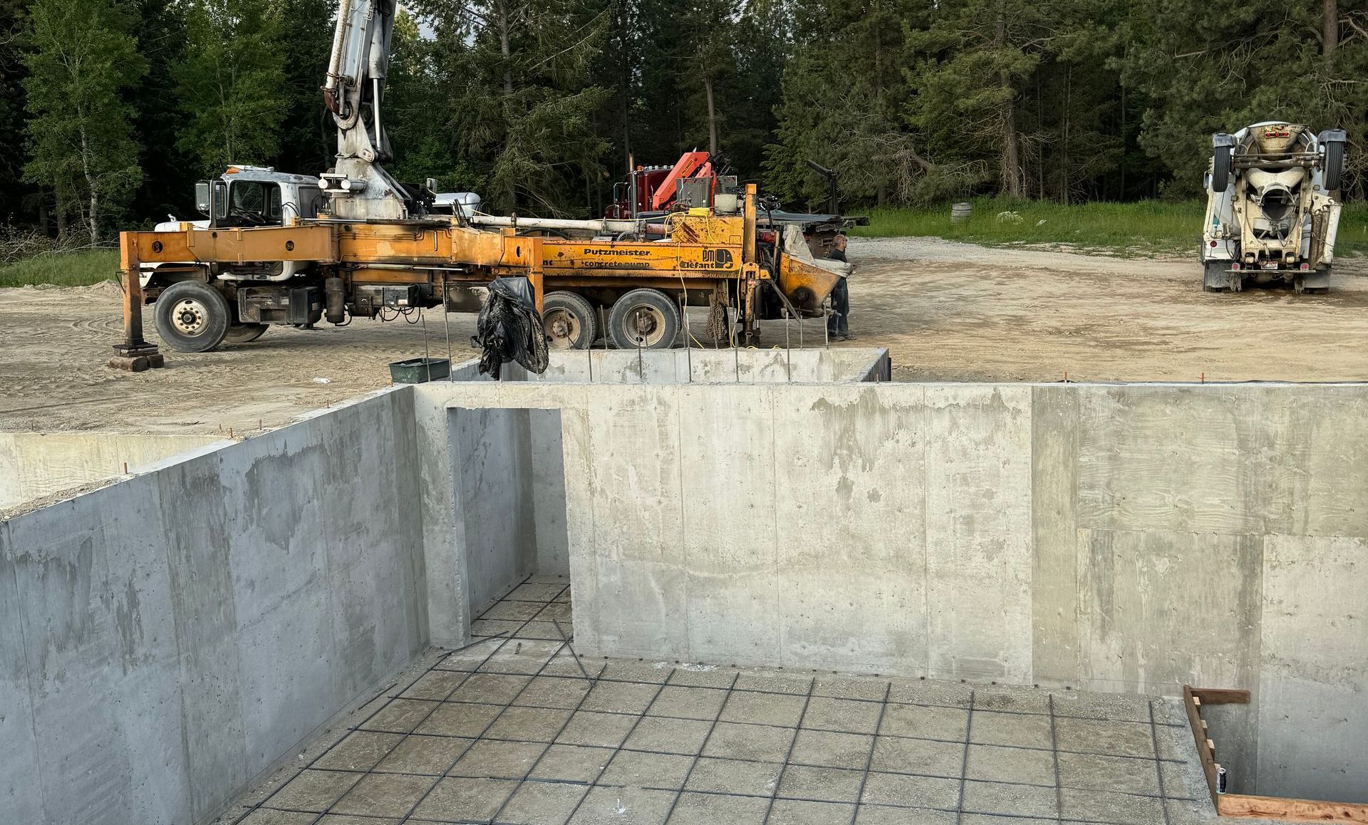 A concrete pump is being used to pump concrete into a pool.