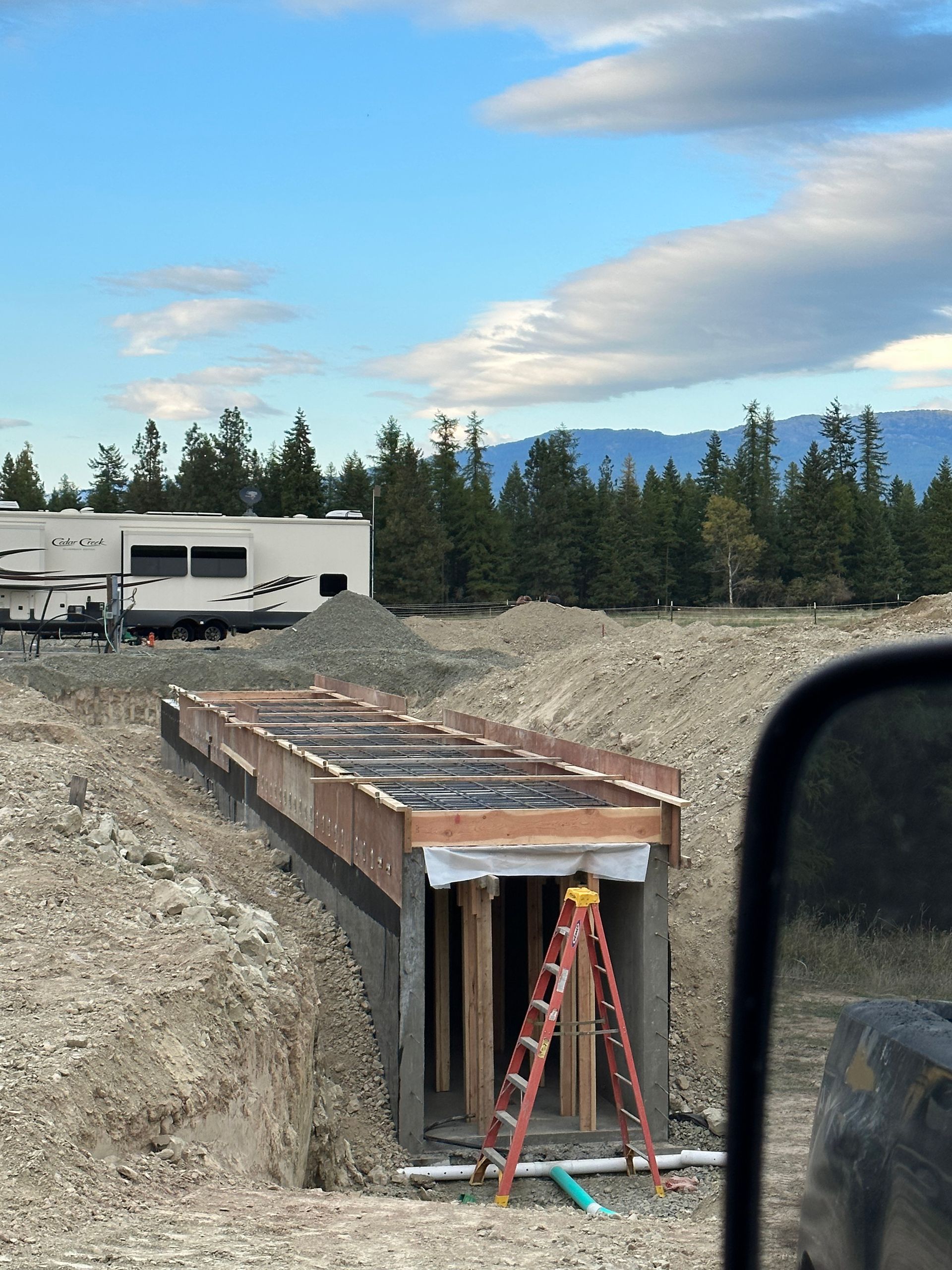 A construction site with a ladder in the foreground. Project done by Raise the Bar Construction