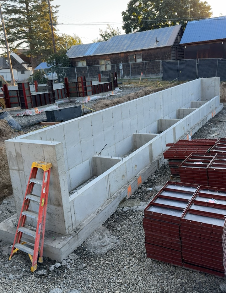 A ladder is sitting on top of a large concrete wall. Project done by Raise the Bar Construction
