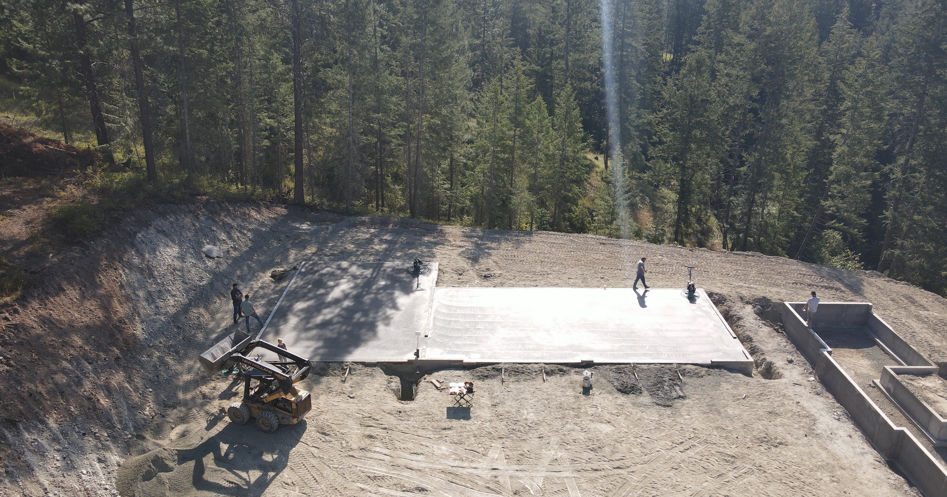 An aerial view of a construction site with trees in the background. Done by Raise the Bar Construction 