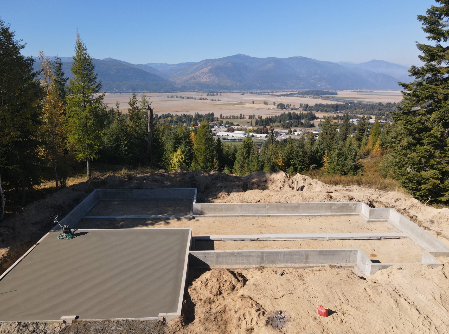 An aerial view of a construction site with mountains in the background. Done by Raise the Bar Construction