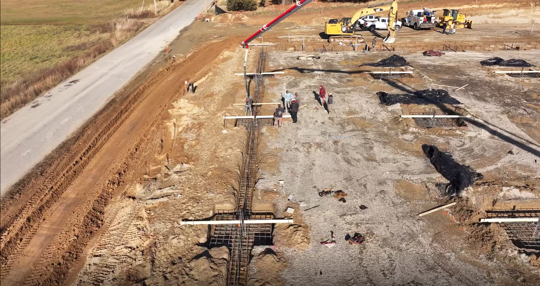 An aerial view of a construction site with a road in the background. Done by Raise the Bar Construction 