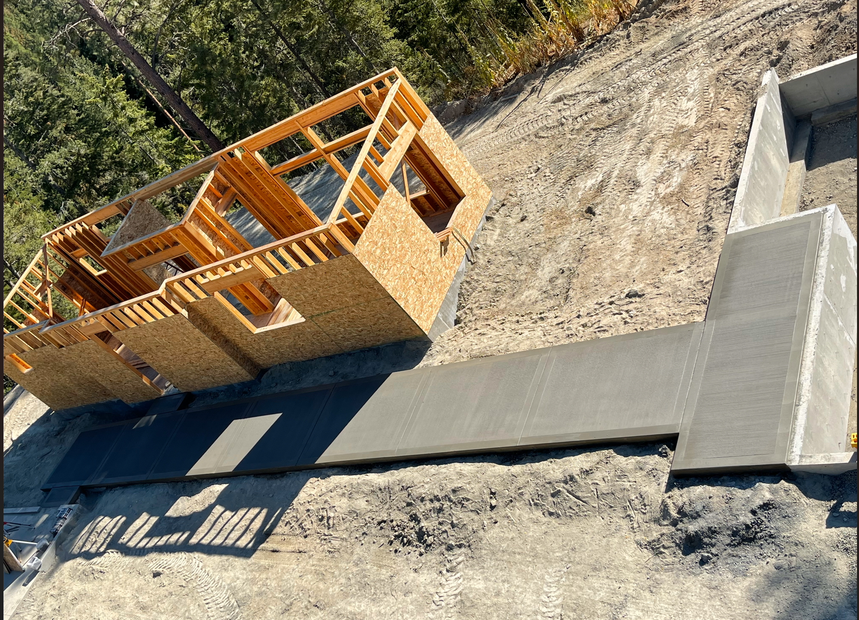 A house is being built on top of a dirt hill. Project done by Raise the Bar Construction