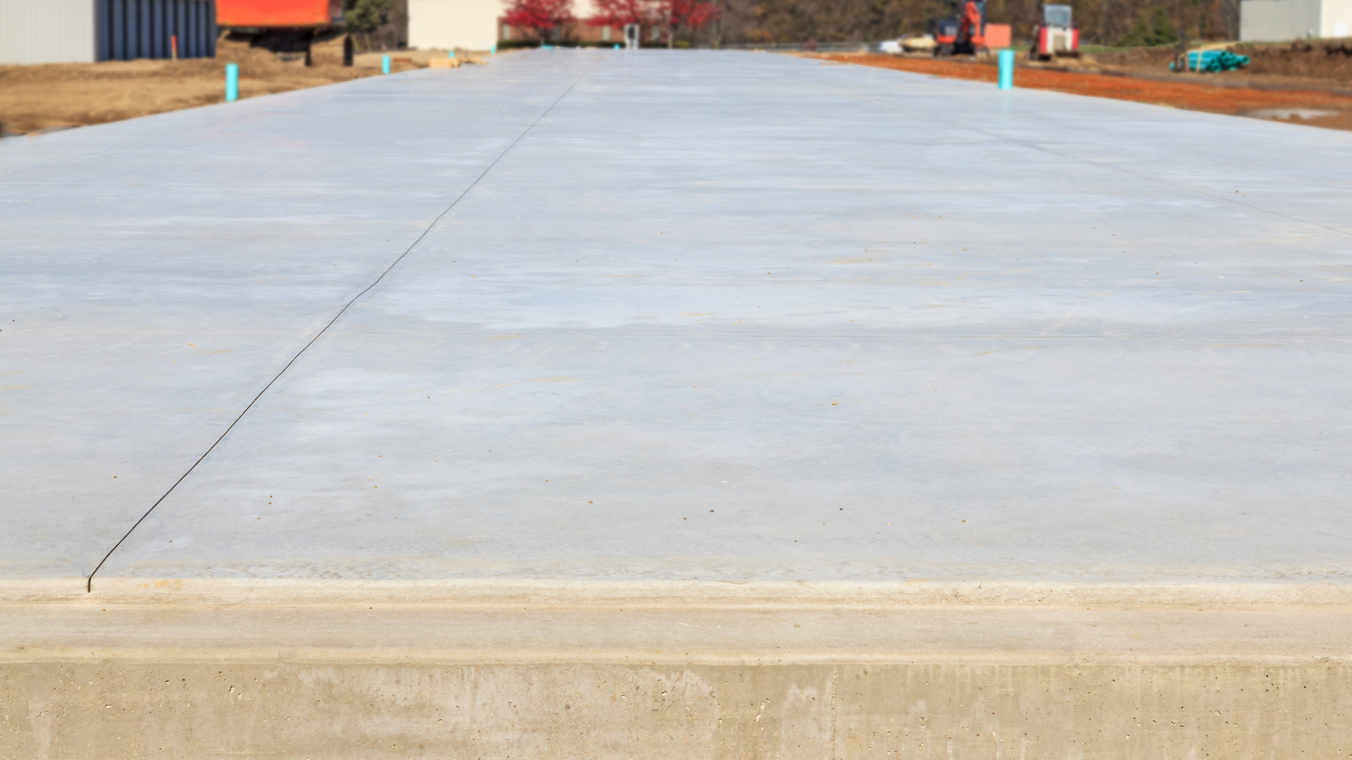 Smooth finished concrete slab foundation at a commercial or residential job site, ready for framing.