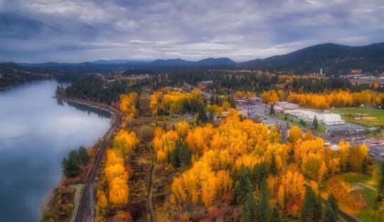An aerial view of a river surrounded by trees and mountains.