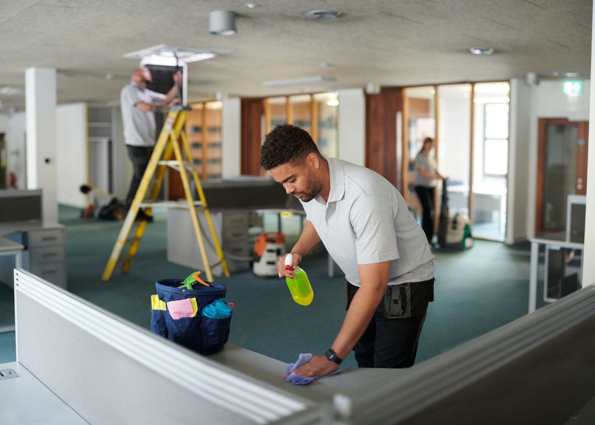 Wide view of a cleaning team doing a deep office clean. Wide view of a cleaning team doing a deep office clean.