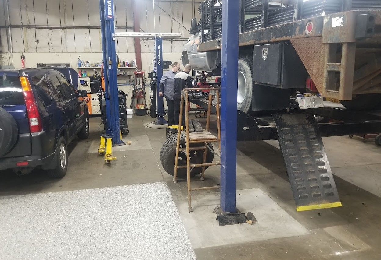 Mechanic shop: Person working under truck on a ramp | 6 to 6 Auto Service