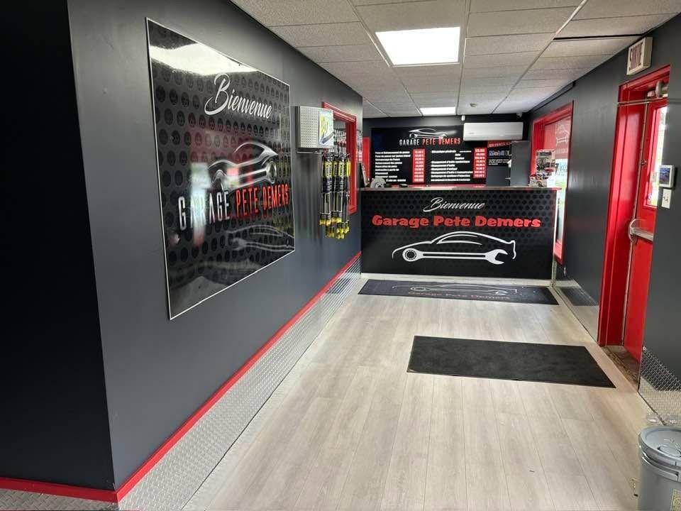 Une voiture rouge est assise sur un ascenseur dans un garage.